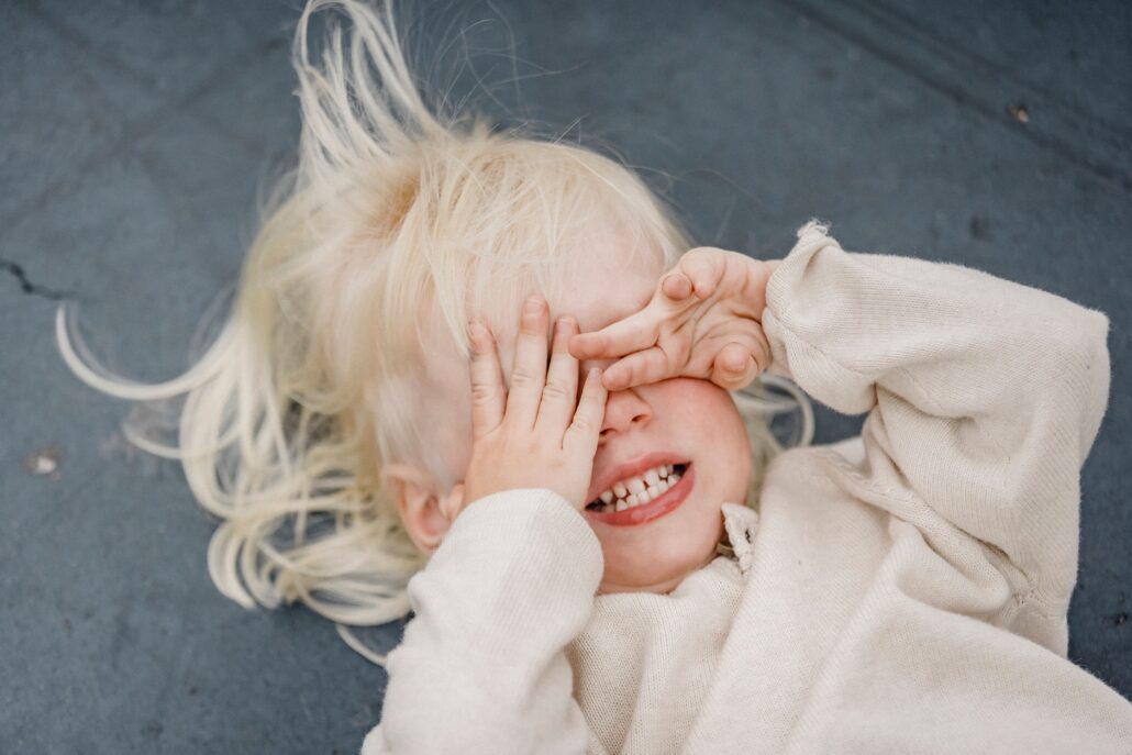 child experiencing sensory overload covering their eyes