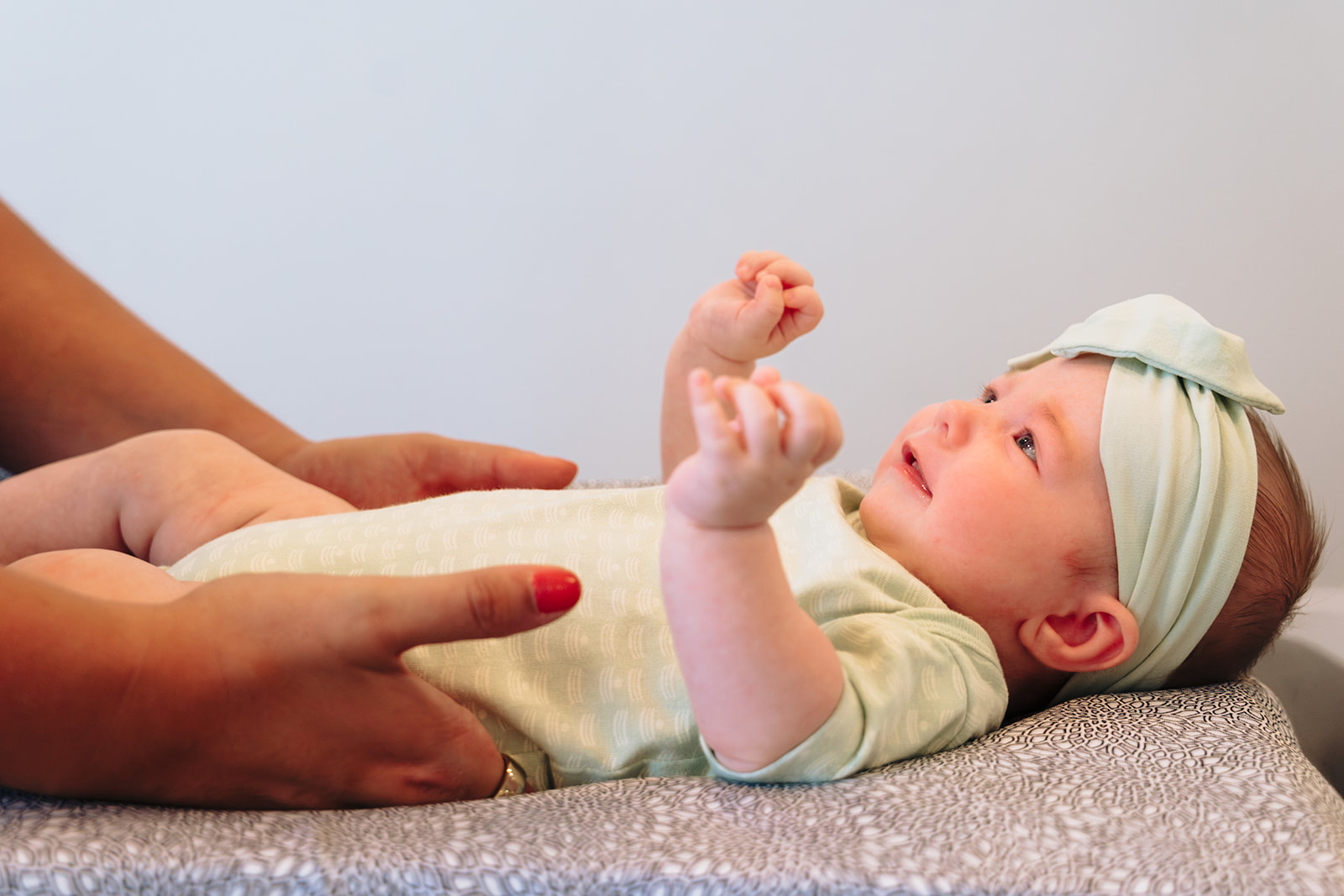 Happy infant laughing during a chiropractic adjustment at Blossom Family Chiropractic