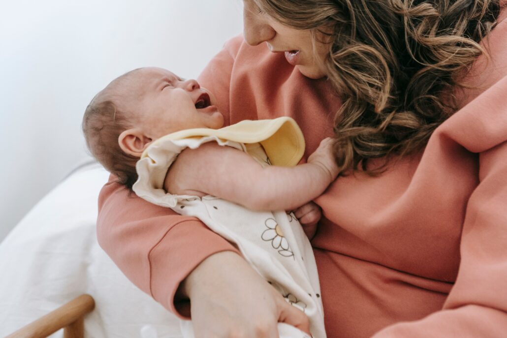 infant crying in mother's arms, experiencing colic with your baby